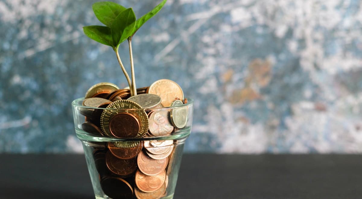 Alcancía con monedas mexicanas y una lista de tips para ahorrar dinero